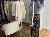 a mannequin in a clothing store next to a chair