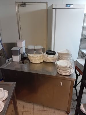 many plates and bowls on the counter in the kitchen