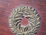 a wooden table with a gold leaf decoration on it