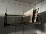 une étagère métallique sur laquelle sont posés un micro-ondes et un four à micro-ondes