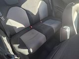 the back seats of a small car are empty in a parking lot