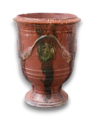 un vase rouge orné d'un cœur sur fond blanc