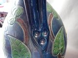 a blue vase with two black birds on it