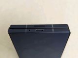 the back of a black cell phone sitting on top of a table