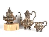 three pieces of silverware sitting on top of a wooden stand