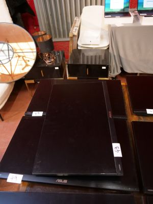 trois ordinateurs portables posés sur une table dans une pièce