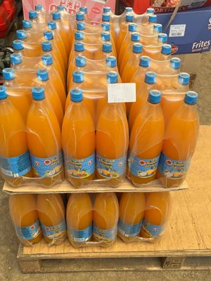 many bottles of orange juice on display in a store