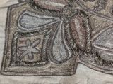 a close up of a piece of embroidery with a butterfly on it