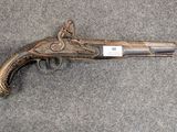 un vieux pistolet est posé par terre à côté d'une paire de ciseaux