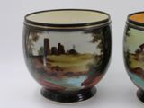 two cups that have been painted with a landscape on them