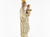 an old statue of a woman holding a child and a golden bowl