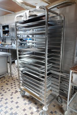 many trays of food sitting on a cart in the kitchen