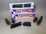quatre petits trains miniatures posés les uns à côté des autres sur une table