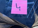 a pile of black plastic bags with a pink sticker on it