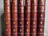 six vieux livres sont alignés sur une table