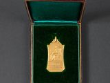a close up of a gold medal in a green box
