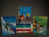 several children ' s books are lined up on a table