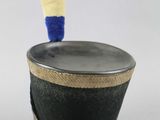 a black hat with a red, white, and blue pom pom sticking out of it