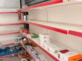many empty shelves in a store with boxes on them