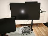 two monitors and a laptop on a table in a room