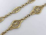 a close up of a pair of gold plated bracelets on a white surface