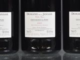 three bottles of wine are lined up on a table