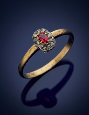 gros plan d'une bague en or avec une pierre rouge