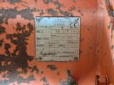 une plaque métallique rouillée sur le flanc d'un véhicule orange rouillé