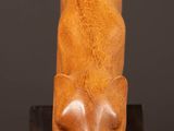 a wooden sculpture of a cat ' s head on top of a wooden block