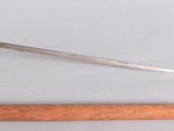 a wooden stick and a metal object on a white surface