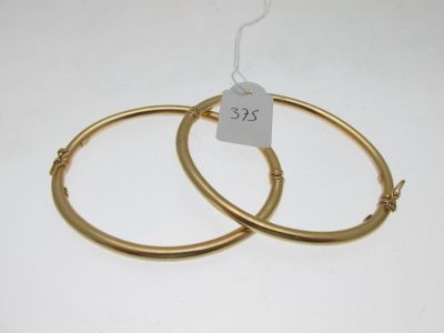 une paire de boucles d'oreilles en or sur fond blanc