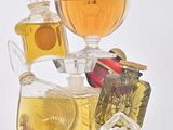 bottles of perfume are stacked on top of each other on a white surface