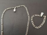 un collier et un bracelet en argent sur un fond noir