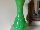 un vase vert posé sur une table en marbre