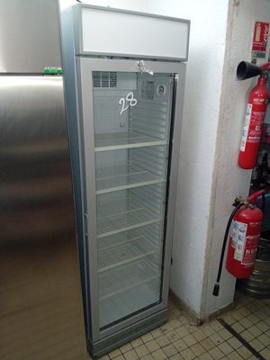 une photo d'un réfrigérateur dans une cuisine, avec un extincteur