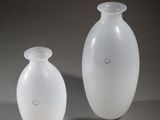 two white vases sitting next to each other on a table