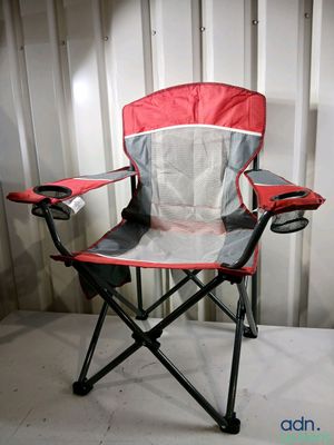 une chaise pliante rouge et grise posée devant un mur blanc