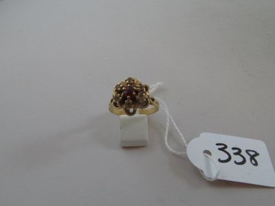 a gold ring with a red stone on it