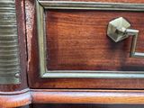 a close up of a wooden dresser with brass handles