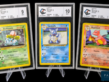 Trois cartes Pokémon différentes sont présentées dans des pochettes en plastique transparent.