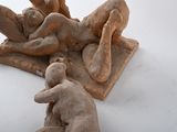 two statues of a man and a woman on a white surface