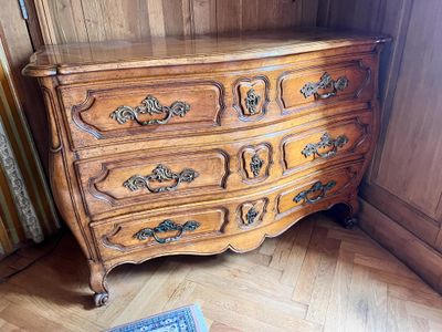 une commode en bois dans une pièce où il y a un tapis au sol