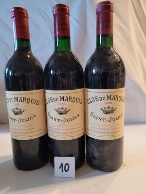 trois bouteilles de vin rouge posées sur une table blanche