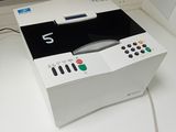 un boîtier blanc sur lequel est posée une télécommande