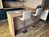 two white stools sitting at the bar in the kitchen