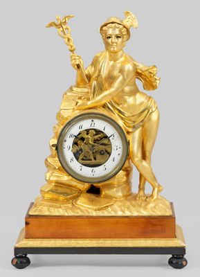a gold clock with a statue on top of it