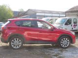 a picture of a red mazda cx - 5 parked in a lot