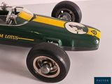 a green and yellow toy race car on a white surface