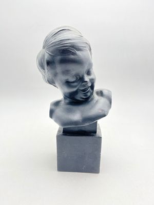 une petite statue représentant un enfant posée sur un petit socle