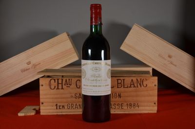 une bouteille de vin posée sur une table, à côté de deux caisses en bois